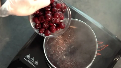 The cook is preparing the sauce. Cook cooks cherries. Berry sauce Stock Footage 126446847