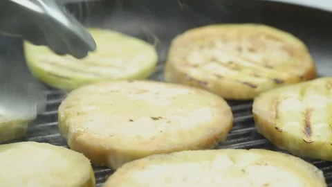 The cook preparing sliced eggplants in a grill pan. Stock Footage 168146226