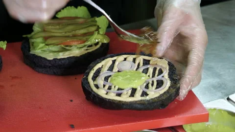 Cook preparing tasty burger with beef or pork rissole, smoked bacon, shrimps. 4K Stock Footage 98034201
