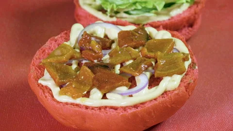 Cook preparing tasty burger with beef or pork rissole, smoked bacon, shrimps. 4K Stock Footage 98035342