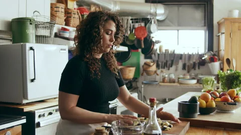 Cook prepping vegetables in a large kitchen with an array of a equipment and app Stock Footage 199456192