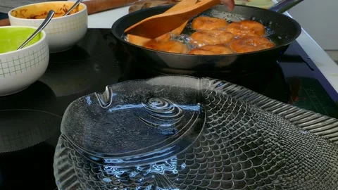 The cook pulls the donuts out of the frying pan. Video stock 86116297