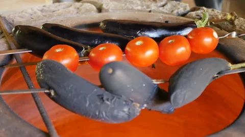 The cook put a skewer with planted whole red tomatoes in a hot tandoor with fire Video stock 201498570