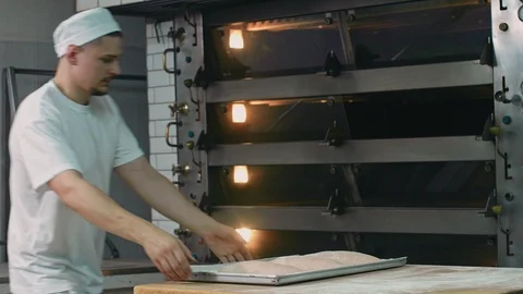 The cook puts the bread in the oven 스톡 동영상 92581533