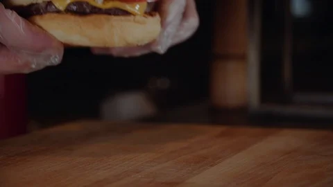 The cook puts burger on wodden serv board. Chef making burger. Vídeo Stock 97795932