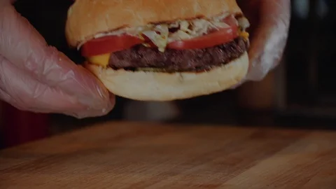 The cook puts burger on wodden serv board. Chef making burger. Stock Footage 97796097