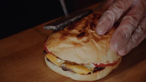 The cook puts burger on wodden serv board. Chef making burger. Vídeo Stock 99363991