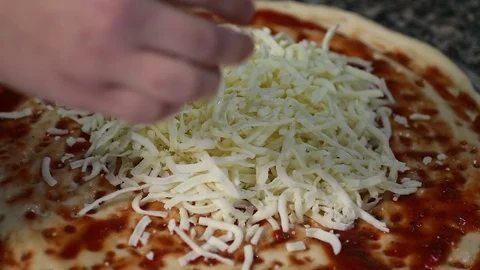 Cook puts cheese on pizza Stock Footage 87635903