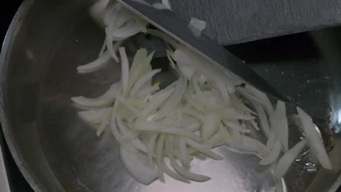 The cook puts the chopped onion in the pan Stock Footage 221496092