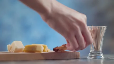 The cook puts crackers on a cheese board Stock Footage 131419306