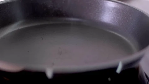 The cook puts a cube of butter in a heated pan Stock Footage 106923958