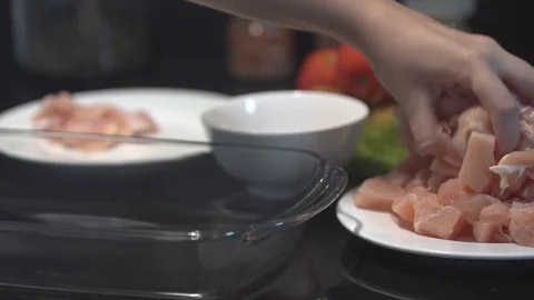 The cook puts cutted chicken breast on the baking tray, raw chicken, chef cooks 動画素材 82592360