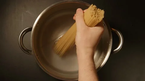 A cook puts down a spaghetti in a steel pot 動画素材 61033376