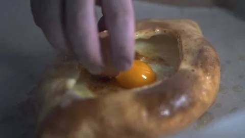 The cook puts an egg in the khachapuri Stock Footage 152467938
