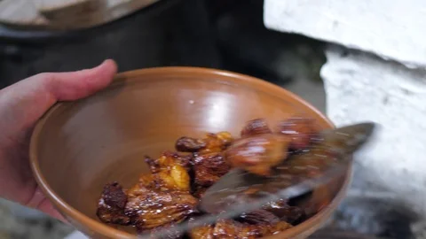 The cook puts the finished meat on a clay dish. fried pieces of meat Stock Footage 125529314