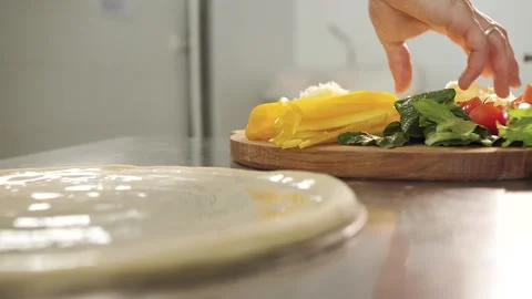 Cook puts his hands on the cheese on the pizza Stock Footage 130557538
