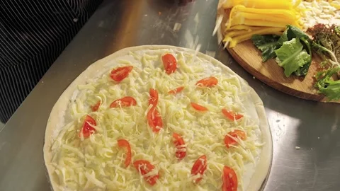 Cook puts his hands on the cheese on the pizza Stock Footage 130557685
