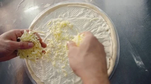 Cook puts his hands on the cheese on the pizza Stock Footage 149976893