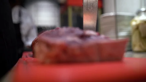 Cook puts his knife in the cutting board with steak in the front Video stock 108110286