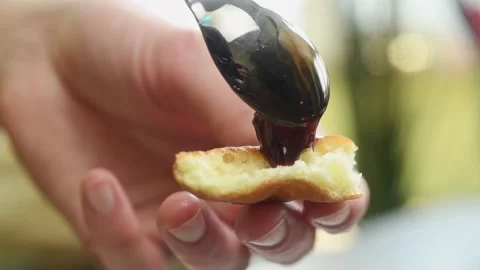 The cook puts the jam on the mekitsa with a spoon. Stock Footage 197466486
