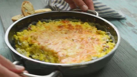 The cook puts the pan with cheesy corn casserole on the table. Stock Footage 210717568