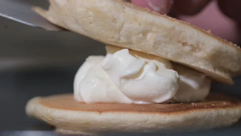 Cook puts pancake on stack of tortillas with white cream 스톡 동영상 161891470
