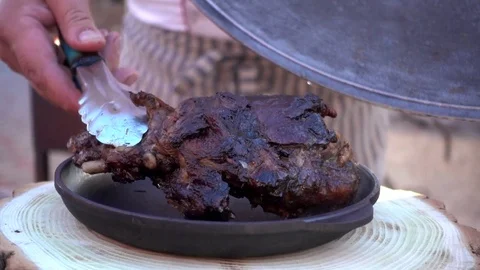 Cook puts a piece of fried meat grill on a Plate Stock Footage 76016352