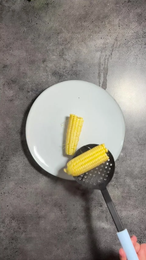Cook puts pieces of half an cob of freshly boiled yellow corn into plate Stock Footage 282688966