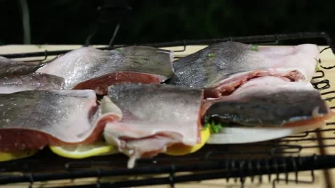 The cook puts pieces of red fish on the grill Stock Footage 134199025