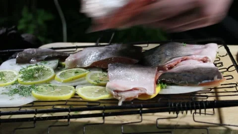 The cook puts pieces of red fish on the grill Stock Footage 134199294