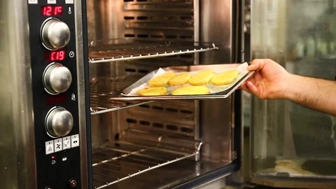 Cook puts the potatoes in the oven Stock Footage 106627897