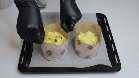 The cook puts raw dough in baking dishes on a baking sheet. Stock Footage 128443154