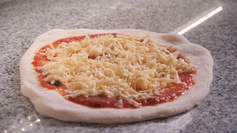 Cook puts raw pizza on huge steel spatula to bake in oven Stock Footage 132473976