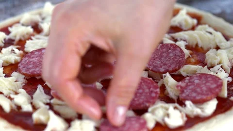 The cook puts salami in pizza. Close-up. Stock Footage 88630954