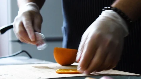 The cook puts a slice of orange on cheesecakes with sweet sauce Stock Footage 112508419
