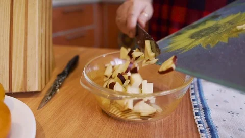 The cook puts the sliced apples in a salad bowl. Slow motion. Stock Footage 123725186