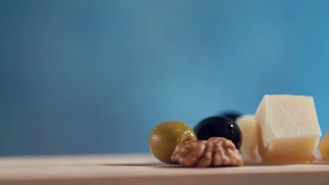 The cook puts some cheese with olives and nuts on the board Stock Footage 131420460