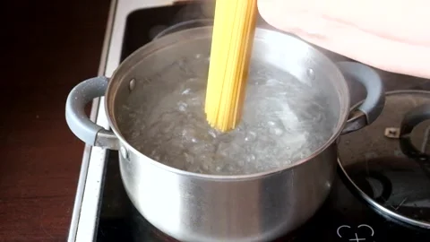 The cook puts the spaghetti into a pan of boiling water Stock Footage 274631043