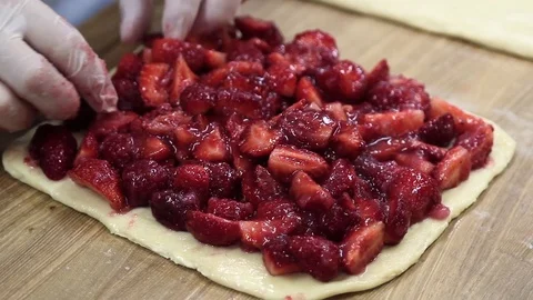 The cook puts the stuffing on a strawberry cake Stock Footage 69994527