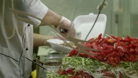 The cook puts vegetables in a container. street food Stock Footage 135677731