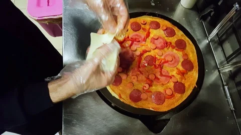 Cook putting some cheese on crepe on a black cooker Stock Footage 103883991