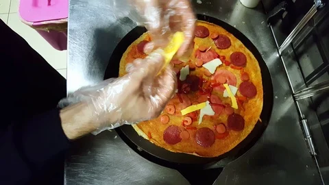 Cook putting some cheese on crepe on a black cooker Stock Footage 103885238