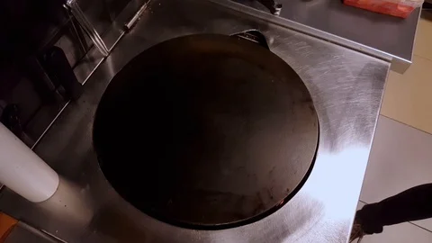 Cook putting some tomato sauce on crepe on a black cooker Stock Footage 103870607