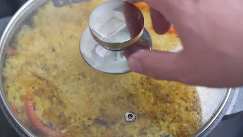 The cook removes the lid from the pot in which the pilaf is being prepared Stock Footage 185046471