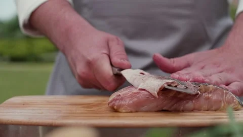 The cook removes the skin from the fish fillet Stock Footage 228041653