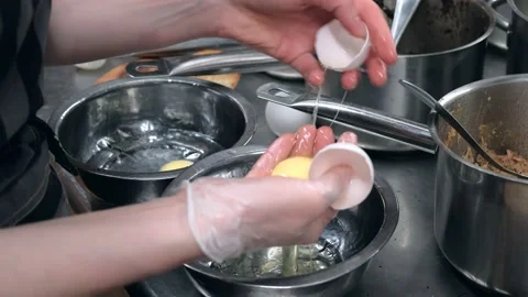 The cook in the restaurant breaks eggs. Separates the protein from the yolk. Video stock 171593062