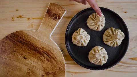 The cook in the restaurant prepares khinkali. On the table there is a frying pan Video stock 191843489