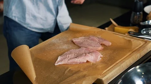 Cook in restaurant prepares meat on baking paper, prepared pieces of meat, salt Stock Footage 122903413