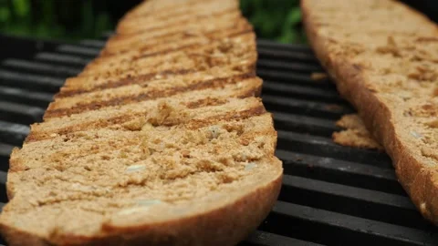 The cook roasts the baguette over the fire for a sandwich. 4K. Stock Footage 134904563