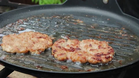 The cook roasts cutlets in a frying pan over an open fire. Stock Footage 134182197